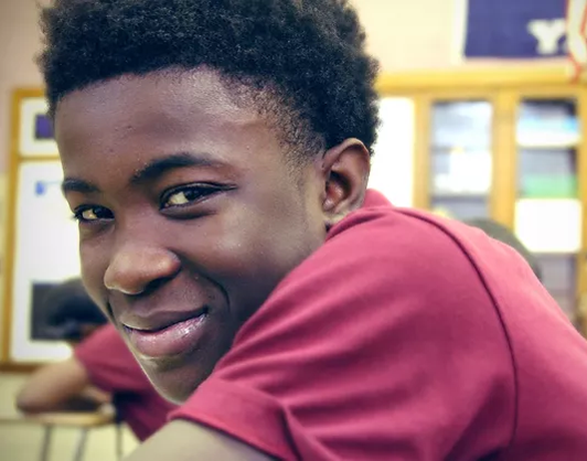 Close up image of a boy smiling at the camera