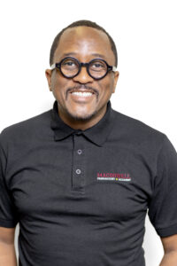 A man wearing black shirt smiling with white background